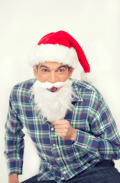 Ευτυχισμένος χαμογελαστός άνθρωπος με πουκάμισο και Χριστούγεννα κόκκινο καπέλο προσποιείται να — Φωτογραφία Αρχείου