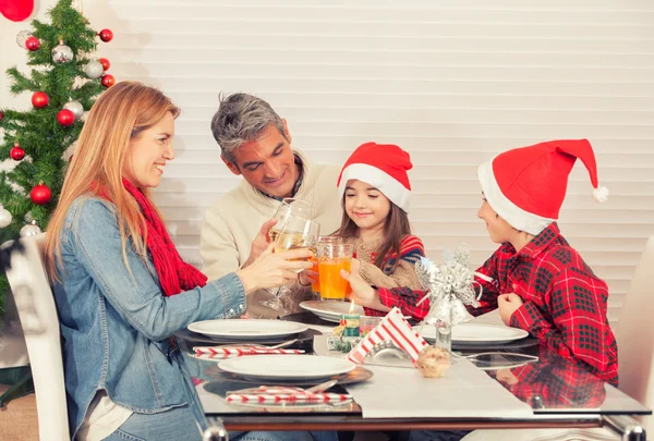 Семейный рождественский стол с елкой на фоне. Родители и дети — стоковое фото