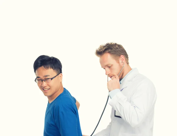 Kaukasiska manlig läkare undersökande asiatiska manlig patient — Stockfoto