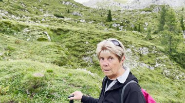 Yaz mevsiminde dağ yolunda yaşlı bir kadın..