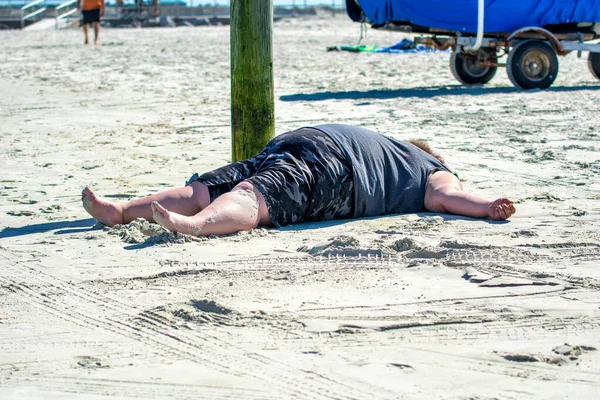 醉了的胖子睡在阳光下的海滩上 — 图库照片
