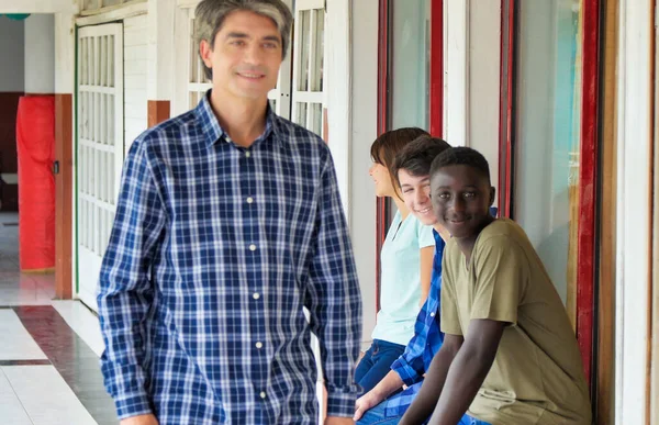 Učitel Kráčí Školní Chodbě Před Jeho Teenager Multietnické Třídy — Stock fotografie