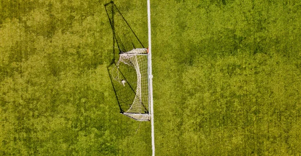 Jogador de futebol ou futebol na parede branca com grama. ângulo amplo.