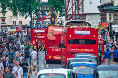 LONDON, İngiltere - 1 Temmuz 2015: Kırmızı Çift Katlı otobüsler kalabalık bir yolda hızla ilerliyor