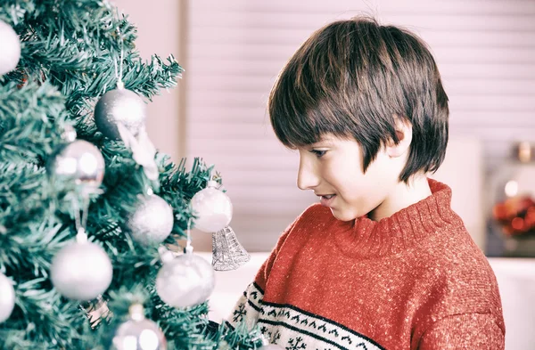 Porträt eines glücklichen Jungen beim Anblick einer dekorativen Spielzeugkugel — Stockfoto