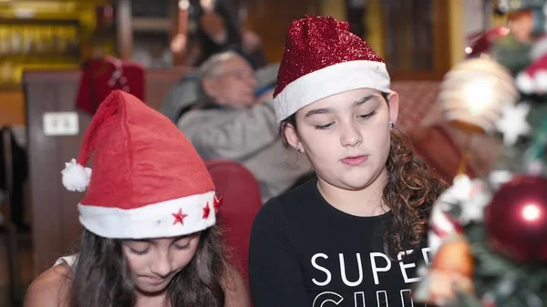 Zwei Junge Schwestern Hause Schmücken Den Weihnachtsbaum Mit Nikolausmütze Urlaubskonzept — Stockfoto