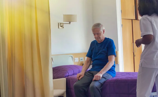 非洲女医生帮助住在医院床上的老年男病人 康复和退休概念 — 图库照片