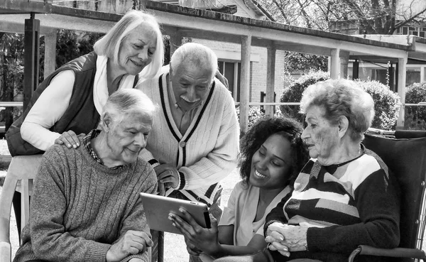 Enfermeira Africana Usando Tablet Com Dois Casais Idosos Aposentados Livre — Fotografia de Stock