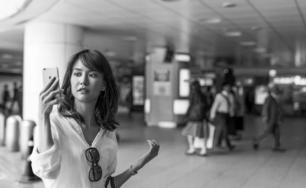 年轻的亚洲女孩在地铁里用智能手机自拍 — 图库照片