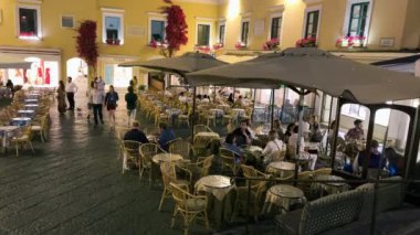 CAPRI, İTALYA - 19 Haziran 2021: Turistler ve yerliler gün batımında ünlü Piazzetta 'nın etrafında yürürler