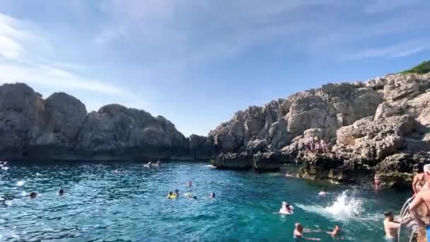 CAPRI, ITALIA - 15 GIUGNO 2021: Turisti e locali nuotano lungo la costa del Faro — Video Stock