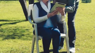 Yaşlı çift tablet kullanarak dışarıda dinleniyor. Etkin Yaşlılar