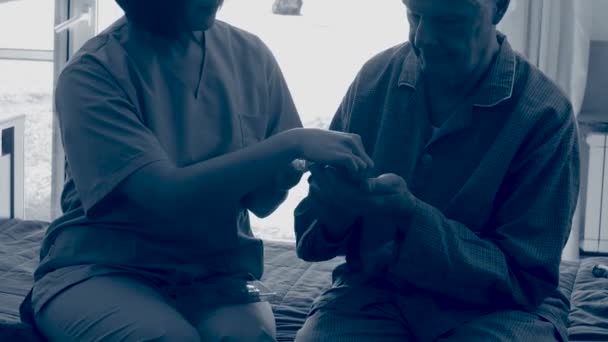 Azjatycki lekarz pomaga starszemu mężczyźnie w podawaniu pigułek medycznych w szpitalu — Wideo stockowe
