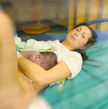Doğumdan sonra hastanede dinlenen anne ve bebek çocuk, yenidoğan ve anne hastanede. İlk dokunuş.