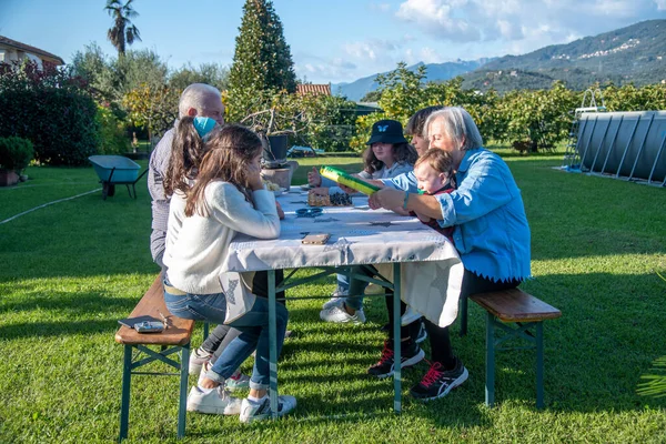 在一个阳光明媚的下午 祖父母和孙子孙女们一起在户外玩桌球 — 图库照片
