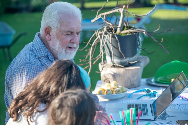 Дедушка Объясняет Пользоваться Ноутбуком Своим Внукам — стоковое фото