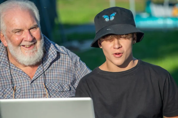 Дедушка Объясняет Внуку Пользоваться Ноутбуком — стоковое фото