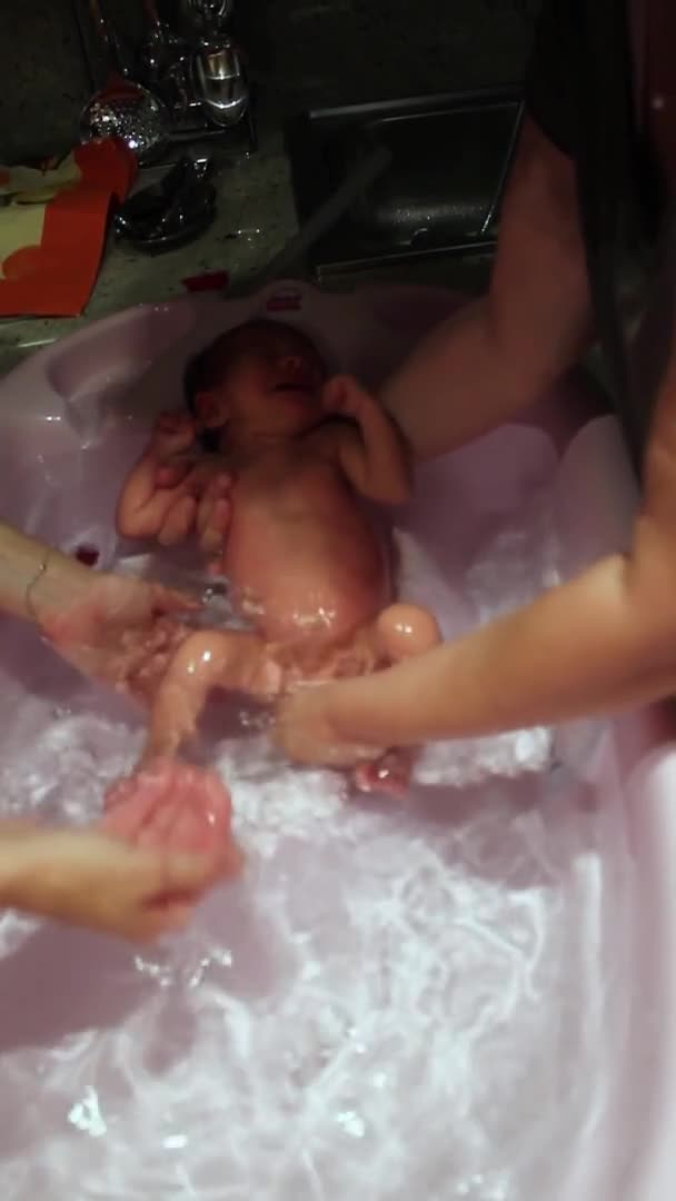 Nouveau-né bébé fille faire son premier bain à la maison — Video