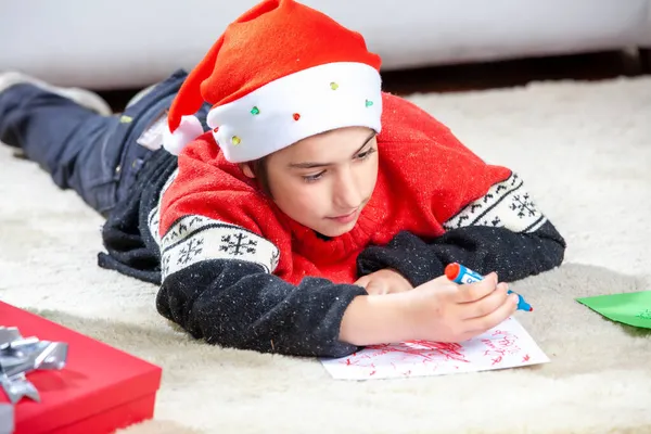 Junge Liegt Weihnachten Mit Roter Mütze Auf Dem Fußboden — Stockfoto