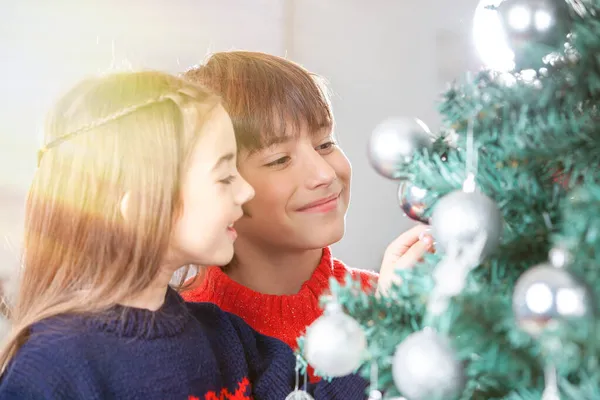 两个快乐的孩子在家里装饰圣诞树 — 图库照片