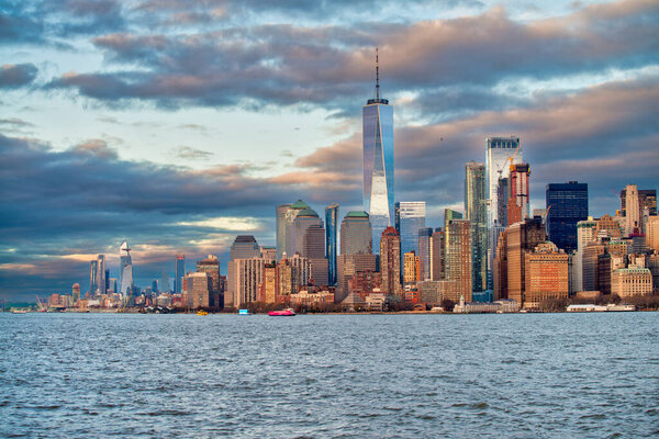 Sunset view of Lower Manhattan skyline from a boat in New York Harbour