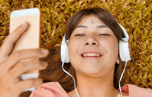 Счастливая Азиатская Девочка Подросток Лежит Траве Слушая Музыку Концепция Освещённости — стоковое фото