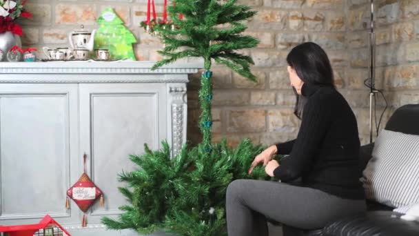 Γυναίκα με την κόρη της προετοιμάζει το Χριστουγεννιάτικο Δέντρο στο σπίτι. Έννοια διακοπών — Αρχείο Βίντεο