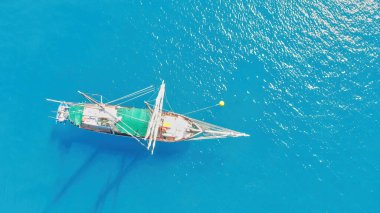Sailing ship sails in a wonderful crystal clear sea, aerial view from drone. clipart