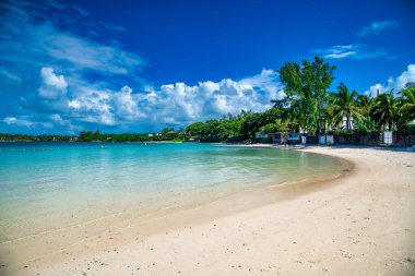 MAURITIUS - 4 Mayıs 2019: Güneşli bir günde turistlerle dolu tropik plaj