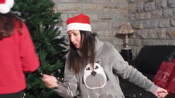 Žena doma zdobí vánoční stromeček s pomocí své mladé dcery — Stock video
