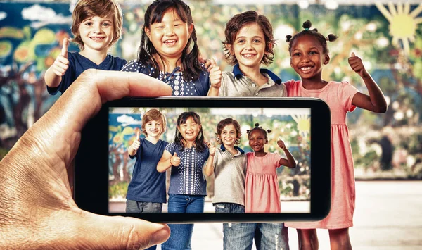Mão Masculina Com Smartphone Tirando Uma Foto Crianças Grupo Sorrindo — Fotografia de Stock
