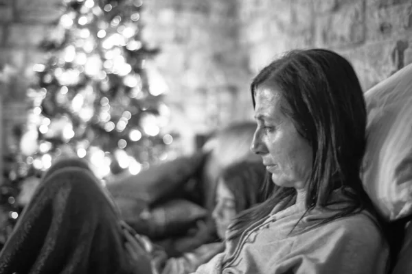 Kanepede Kızıyla Oturan Noel Akıllı Telefonuyla Rahatlayan Bir Kadın — Stok fotoğraf