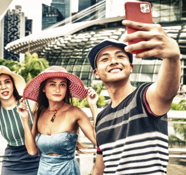Şehirde yürüyen ve selfie çeken üç melez cinsiyet arkadaşı. Turizm ve tatil konsepti.