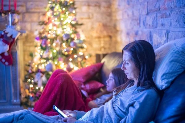 Woman Sofa Her Daughter Relaxing Smartphone Christmas — Foto Stock