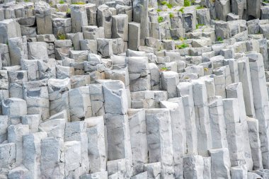 İzlanda kaya oluşumları. Reynisfjara 'nın kara plajı ve güney kıyısındaki Dyrholaey promontory' den bazalt kaya oluşumları.