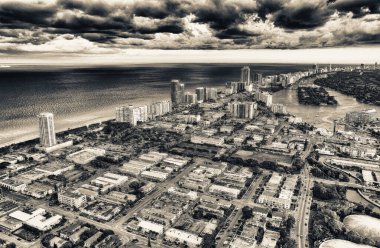 Günbatımında helikopter havadan görünümü Miami Beach. Şehir manzarası ve su. Bulutlu gökyüzü, bir tatil rüya.