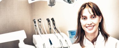 Gülümseyen dişçi dişçisinde duruyor..