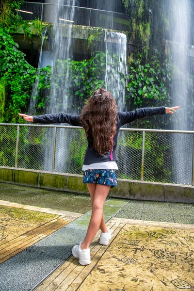 幸せな若いです女の子抱擁自然の下で美しい滝 — ストック写真