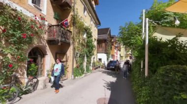 HALLSTATT, AUSTRIA - 3 Eylül 2021: Turistler güzel bir yaz gününde şehir sokaklarının tadını çıkarıyorlar.