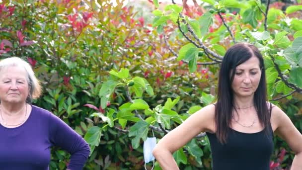 Cuatro mujeres que tienen fitness al aire libre con mascarilla colgando de los árboles — Vídeos de Stock