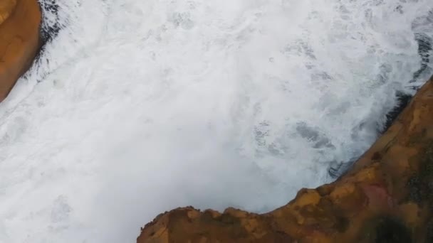 Wildlife coastline with crushing waves against the rocks, overhead aerial view — Vídeo de Stock