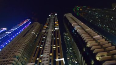 DUBAI, BAE - 5 Aralık 2016: Gökdelen ışıklarıyla Dubai Marina boyunca yürümek