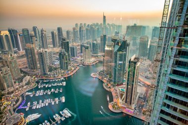 DUBAI, BAE - 5 ARALIK 2016: Gün batımında Dubai Marina binaları. Su boyunca gökdelenler, hava manzarası
