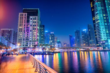 DUBAI, BAE - 5 Aralık 2016: Gece Dubai Marina binaları. Su boyunca gökdelenler