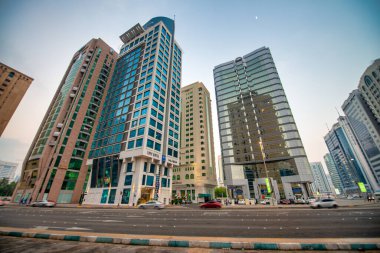 ABU DHABI, BAE - 7 Aralık 2016: Güneşli bir öğleden sonra güzel bir şehir caddesi ve binalar