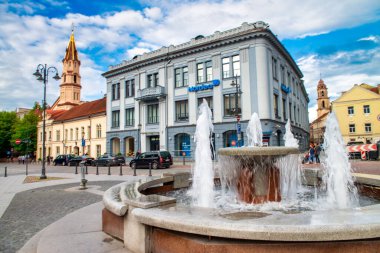 VILNIUS, LITHUANIA - 9 Temmuz 2017: Rotus Meydanı 'ndaki Belediye Meydanı Çeşmesi. Güneşli Yaz Gününde Aziz Nicholas Kilisesi