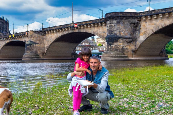 晴れた日に娘と一緒に街の川沿いの幸せな男 — ストック写真