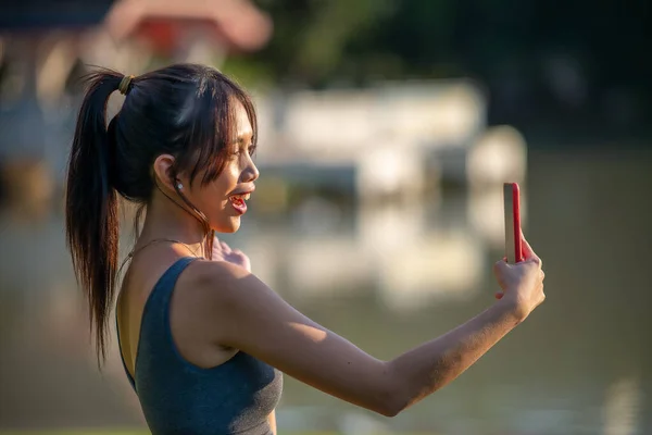 Mladá Krásná Asijská Žena Cvičení Městském Parku Pomocí Svého Smartphonu — Stock fotografie