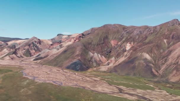 Híres izlandi táj a felföldön, Landmannalaugar terület - Izland. Zöld lávamezők és hegyek a háttérben, légi kilátás a drónról — Stock videók