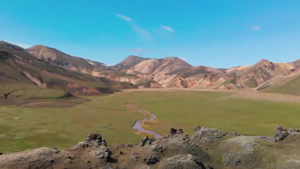 Знаменитий ісландський ландшафт у високогір'ях, Ландманналаугар - Ісландія. Зелені лавові поля та гори на задньому плані, вигляд з повітря з дрона. — стокове відео